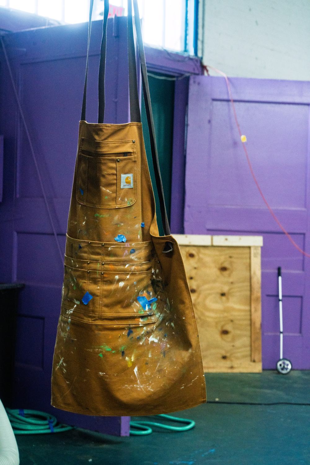 A canvas printing apron covered in years of dried ink, hanging in the shop.