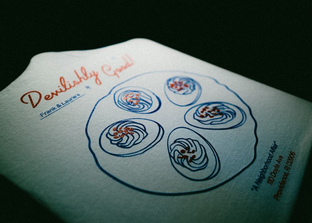 Raking light across the finished Frank & Laurie’s print, showing a clean ink lay on a hand-drawn plate of oysters.